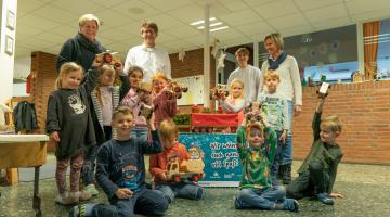 Foto der Spendenübergabe bei der Kindertageseinrichtung St. Paul. V. l. n. r. Erzie- herin Birgit Hullerum; Jürgen Elmer, Geschäftsführer der Stadtwerke Bocholt GmbH (SWB); Elija Cürsgen, Auszubildender bei der Bocholter Energie- und Wasserversorgung GmbH (BEW) sowie Maria Kolks, Leiterin der KiTa St. Paul mit einigen Kindergartenkindern. 