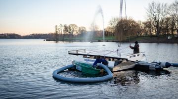 Bild: Mitarbeiter der Spezialfirma aus Freudenstadt lassen eine der schwimmenden Pumpen ins Wasser (Copyright: Stadt Bocholt)