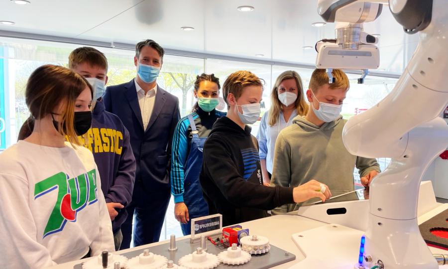 Milena Reinhardt, Jaden Wyss und Lukas Keil (im Vordergrund von links) transportierten mit Roboter „Panda“ Zahnräder an die richtige Stelle. Nach dem Besuch des InfoTrucks erkundeten sie die Firmenhallen der Pieron GmbH, geführt von (im Hintergrund von links) Azubi Torben Wilting, Chef Sven Pieron und Ausbildungsleiterin Jennifer Steffens. Diese Berufsorientierung der besonderen Art hatte 2   der Unternehmerverband organisiert; rechts hinten im Bild: Jennifer Middelkamp von der Regionalgeschäftsführung. (Fo