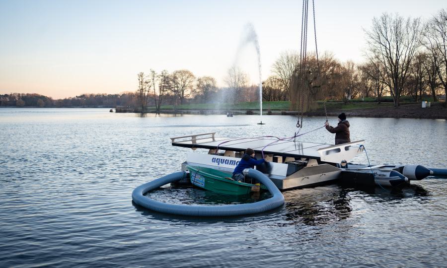 Bild: Mitarbeiter der Spezialfirma aus Freudenstadt lassen eine der schwimmenden Pumpen ins Wasser (Copyright: Stadt Bocholt)