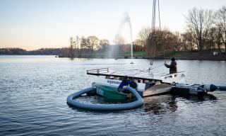 Bild: Mitarbeiter der Spezialfirma aus Freudenstadt lassen eine der schwimmenden Pumpen ins Wasser (Copyright: Stadt Bocholt)